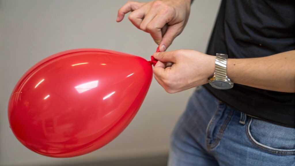 A person testing the stretch of a balloon