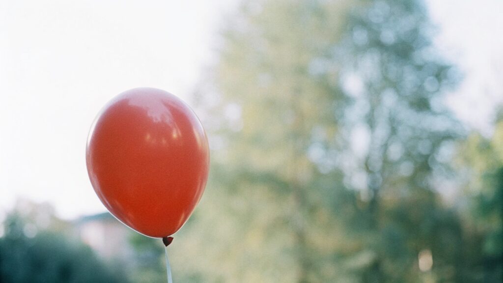 A close-up of a vibrant red latex balloon