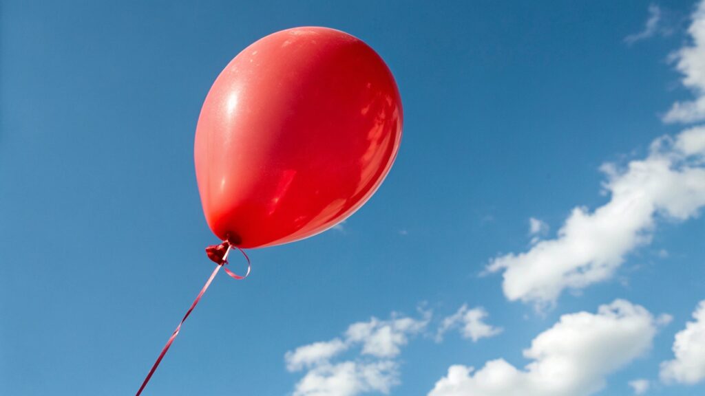 A red balloon floating in the sky