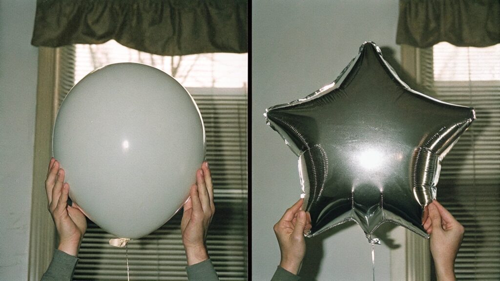 Hands holding both latex and mylar balloons