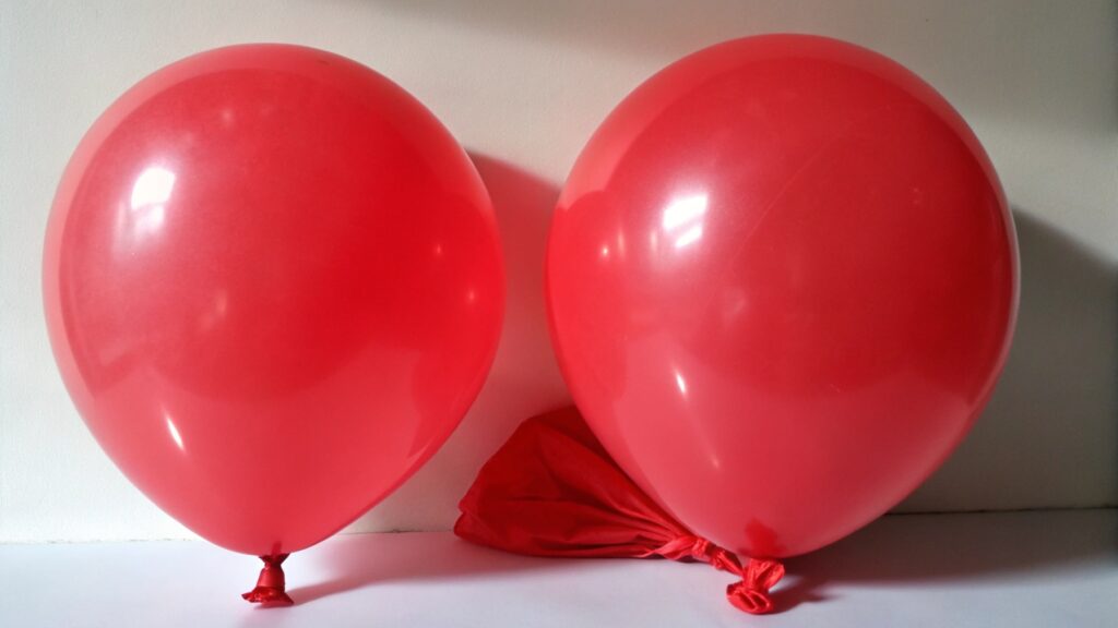 Partially deflated balloon next to a fresh one