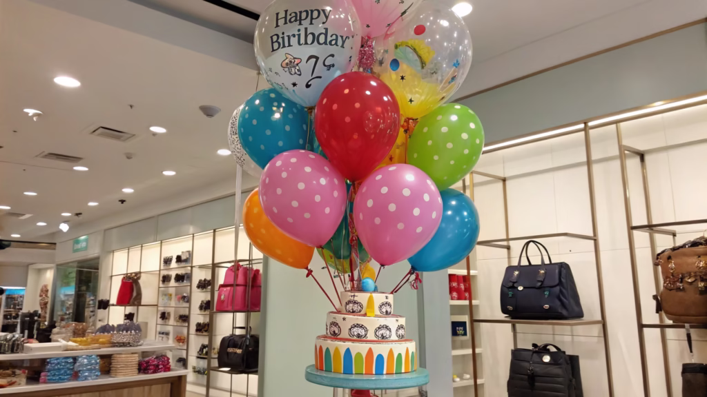 A colorful, multi-level balloon bouquet with a matching weight