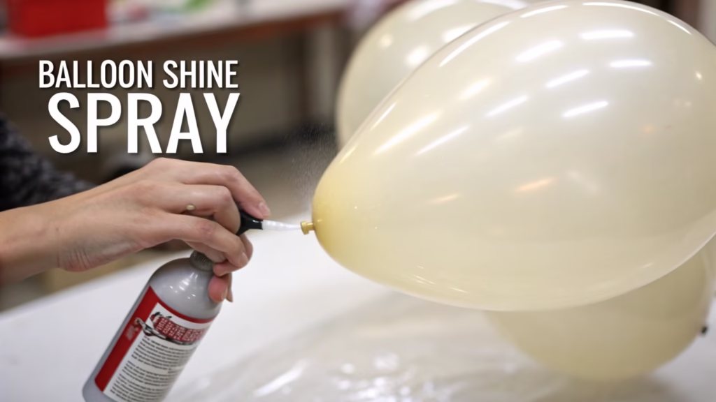 A hand applying a high-shine treatment to a latex balloon