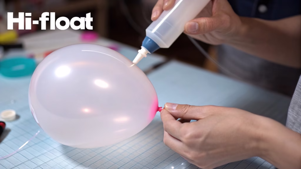 A person demonstrating the correct way to apply Hi-Float inside a balloon