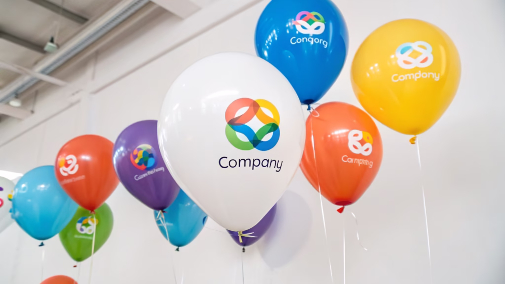 A collection of latex balloons with complex, multi-color company logos printed on them