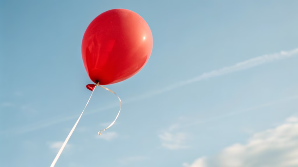 A single 11-inch helium balloon floating with a string