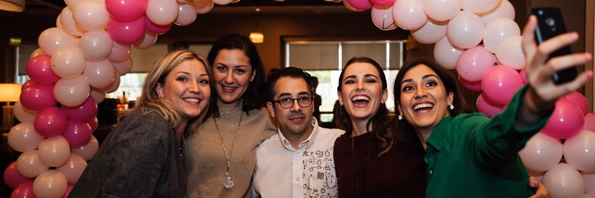 Corporate event attendees taking photos with branded balloon decorations