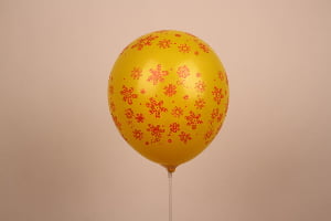 Inflated yellow latex balloon with printed floral pattern